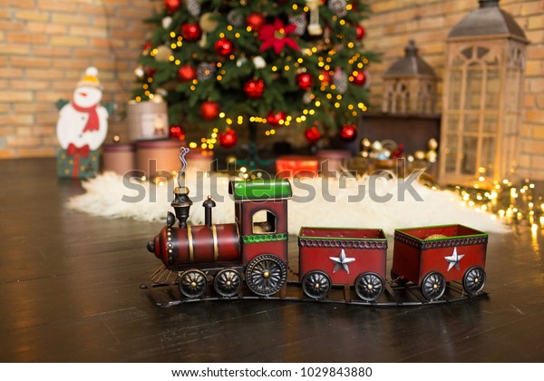 christmas train and a tree with decorations at\
the background