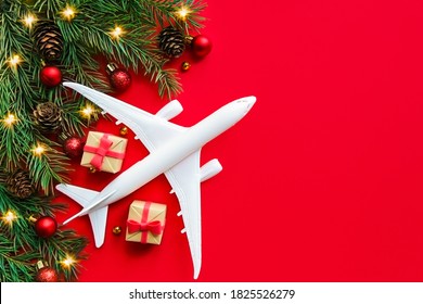 Christmas Travel Planning. Travel As A Gift. White Model Of A Passenger Plane And Gift Boxes On A Christmas Background. Top View Or Flat Lay. Copy Space.