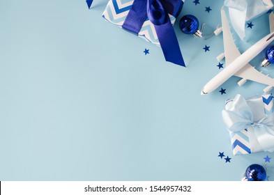 Christmas Travel Presents. Trip For Christmas Time. Toy Of Passenger Plane With Passports And Gift Boxes On Blue Background. Top View Or Flat Lay. Copy Space.