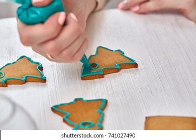 Christmas Treats. Handmade Cookies, Confection Standing On The Table. Female Hands Decorating Gingerbread With Icing Sugar Using A Pipping Bag. Baking Holiday Cookies. Christmas And New Year.