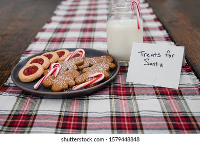 Christmas Treats And Milk On A Plaid Table Runner With A Note For Santa Claus 