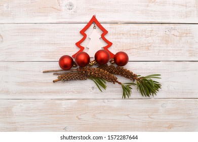 Christmas Tree, Ball Ornaments And Bottlebrush Plant Seed Pods On Whitewashed Wood Background