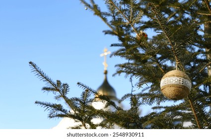 Christmas tree branch with decorations on the background of an Orthodox cross with a crucifix. Orthodox church. Winter - Christmas, New Year. The concept of Orthodoxy. - Powered by Shutterstock