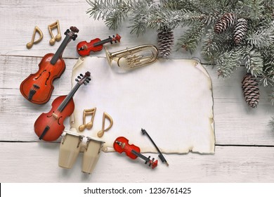 Christmas Tree Branch With Music Instruments And Paper  On Wooden Background 