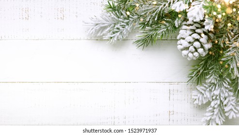 Christmas tree branch and pine cone in snow on a white wooden background. Winter festive concept. Flat lay, copy space. - Powered by Shutterstock