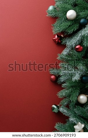 Christmas tree branches creating a vertical side border on red background.