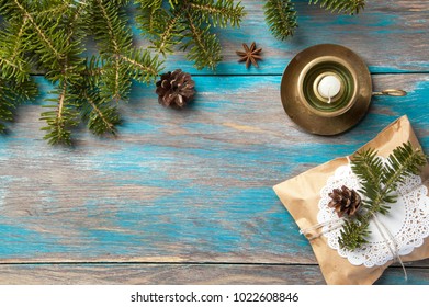 Christmas tree branches ,gift box and vintage brass candlestick with white candle on shabby blue wooden background. Christmas decorations, copy space for text. - Shutterstock ID 1022608846