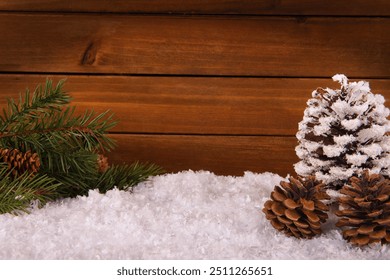 Christmas tree branches, pine cone and snow on natural wooden plank background. Copy space for your text. - Powered by Shutterstock