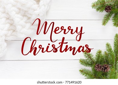 Christmas tree branches and white scarf on a white wooden table with fir branches - Shutterstock ID 771491620