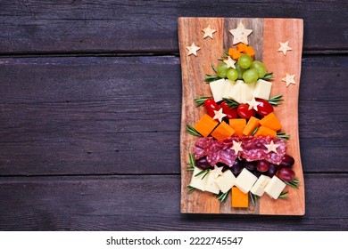 Christmas tree charcuterie board. Top view over a dark wood background. Selection of cheese and meat appetizers. - Powered by Shutterstock