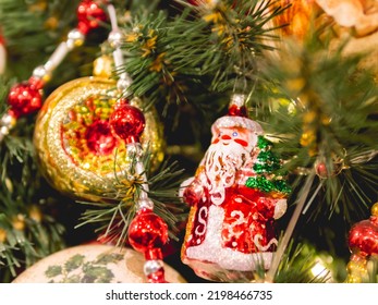 Christmas Tree With Colorful Outdoor Decorations. Fir Tree Decorated With Light Bulbs And Old Fashioned Santa Claus For New Year Celebration.