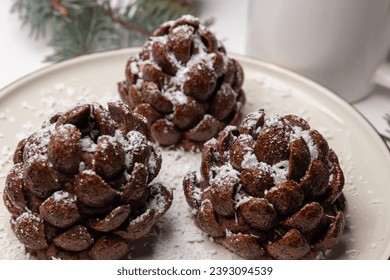 Christmas tree cone-shaped cookies with chocolate flakes with powdered sugar, a delightful homemade dessert for the New Year. These chocolate pine cone-shaped shortbread cookies with sweet snow. - Powered by Shutterstock