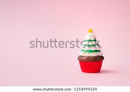Christmas tree cupcake on pink background with copy space. Minimal Christmas theme. New year food concept.