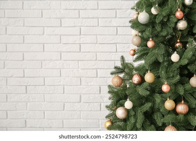 Christmas tree decorated with baubles near white brick wall - Powered by Shutterstock