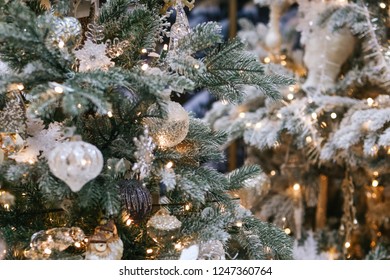 Christmas tree decorated with white toys and a garland with lights, background