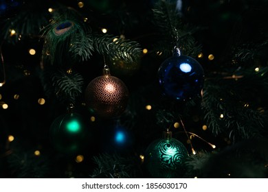 Christmas tree decoration: Christmas decorations, glow lights, the decorations in the form of a peacock feather. concept: interior for a living room with a blue wall, postcard or poster.