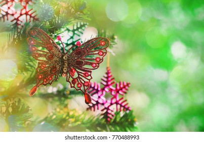 Christmas tree decoration with red butterfly and Christmas color snowflake with green white bokeh light background