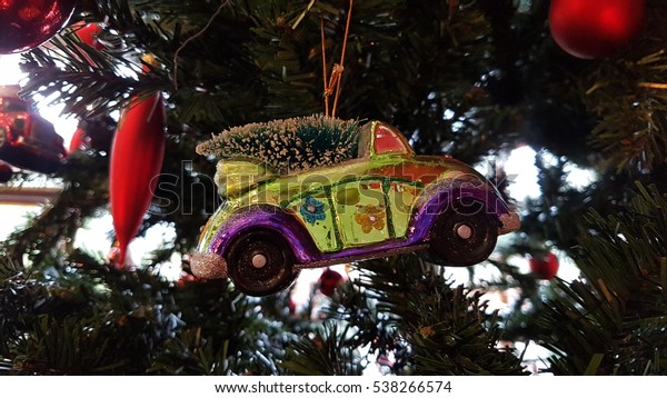 Christmas tree decoration. It\'s a yellow car with a\
christmas tree on the\
roof!