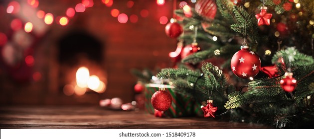 Рождественская елка с украшениями возле камина с подсветкой