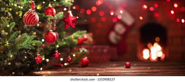 Christmas Tree With Decorations Near A Fireplace With Lights