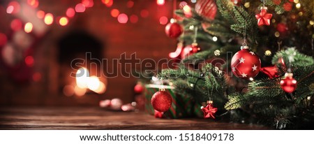 Christmas Tree with Decorations Near a Fireplace with Lights