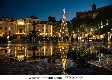 Christmas Tree and Festive Lights Reflected on Wet Pavement at Rossio Square in Lisbon, Portugal
