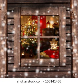 Christmas Tree And Fireplace Seen Through A Wooden Cabin Window