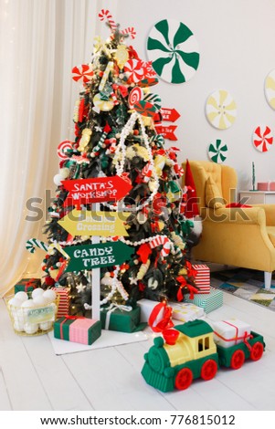 Christmas Tree and Christmas gift boxes in the interior with armchair