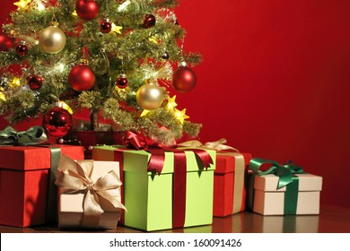 Christmas tree with gifts on red background.