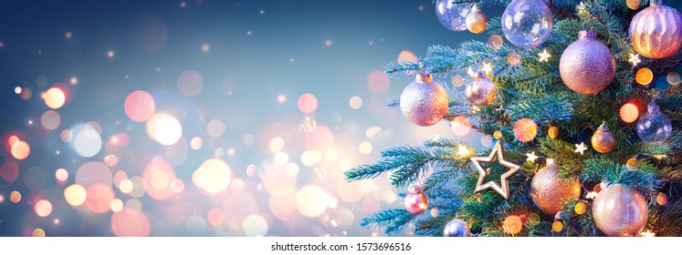 Christmas Tree With Golden Baubles And Shiny Lights In Blue Background
