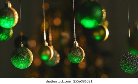 Christmas tree golden and green balls highlighted by neon light hanging from above, glittering ornaments garland close shot on blurred festive background. - Powered by Shutterstock