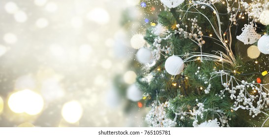 christmas tree with holiday white decorations and lights on silver background with copy space