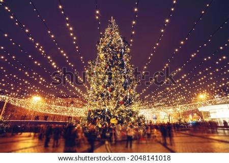 Christmas tree and lights at night in Kyiv. People in blurred motion
