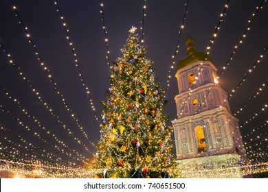 Christmas tree with lights outdoors at night in Kiev. Sophia Cathedral on background. New Year Celebration - Powered by Shutterstock