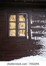 Christmas Tree With Lights Seen Through A Wooden Cabin Window