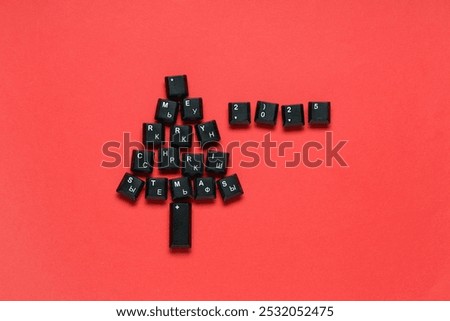Christmas tree made of black computer keys on red background
