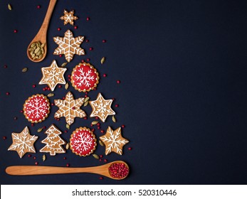 christmas tree made from gingerbread cookies and wooden spoons with spices on dark blue background with copy space for text. holiday, celebration and cooking concept. new year and christmas postcard - Powered by Shutterstock