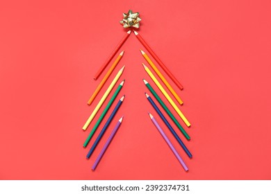 Christmas tree made of pencils in LGBT colors with bow on red background - Powered by Shutterstock