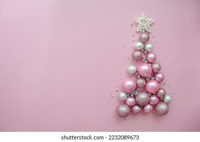 Christmas tree made of stars, confetti, pink balls on pink background. Flat lay, top view. Xmas greeting card with text - Merry Christmas. - Powered by Shutterstock