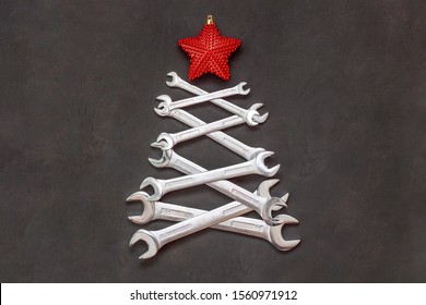 Christmas tree made of tools. Wrenches spanners on black background. Industrial greeting card and happy new year creative concept.