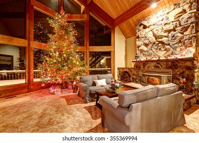 Christmas Tree With Mountain Cedar Rustic Home With Wooden Ceiling And Large Rock Fireplace. Living Room Interior.