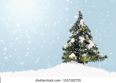 Christmas Tree On Fake Snow With Copy Space On Blue Background.