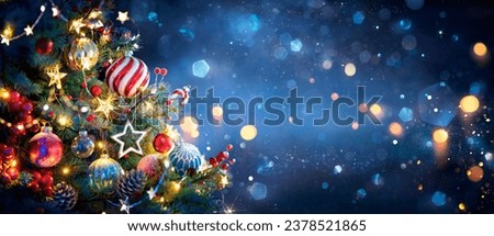 Christmas Tree With Ornaments In Blue And Defocused Lights -  Baubles Hanging On Fir Branches With Glittering In Abstract Background