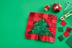 Christmas Tree Patchwork Block, Bright Square Pieces Of Fabric, Pincushion, Quilting And Sewing Accessories On Green Background