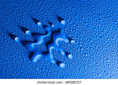 A Christmas Tree Shape Between Blue Water Drops