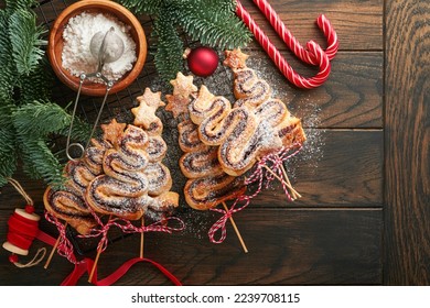 Christmas tree shape puff pastry cakes with chocolate filling, sugar powder and lollipops on old wooden background. Christmas, New Year Appetizer. Festive idea for Christmas or New Year dinner. - Powered by Shutterstock