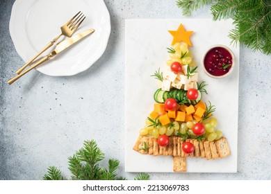 Christmas tree shaped Cheese Plate with crackers, grapes, cheese, tomatoes and cranberry sauce, winter holidays snack. Top view copy space - Powered by Shutterstock