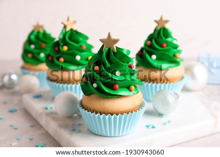 Christmas tree shaped cupcakes and decor on table
