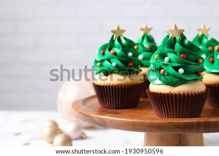 Christmas tree shaped cupcakes on wooden stand. Space for text
