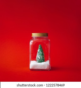 Christmas tree with snow in a glass jar. Creative winter background. Flat lay, top view.